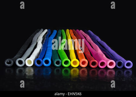 Arc-en-ciel de l'onu-colorés ballons gonflés alignés sur fond noir Banque D'Images