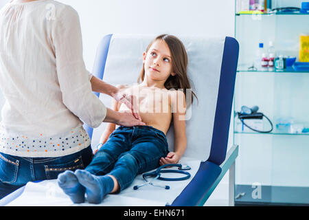 Doctor examining a young girl's de l'abdomen. Banque D'Images