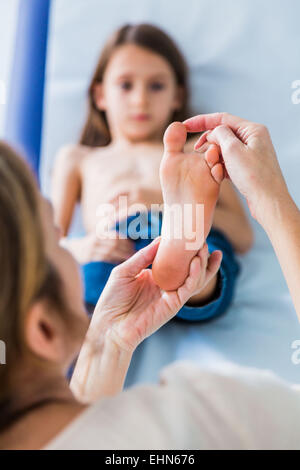 Doctor examining girl's foot. Banque D'Images