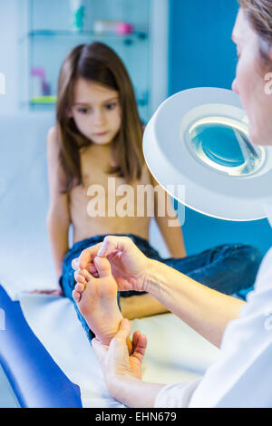 Doctor examining girl's foot. Banque D'Images