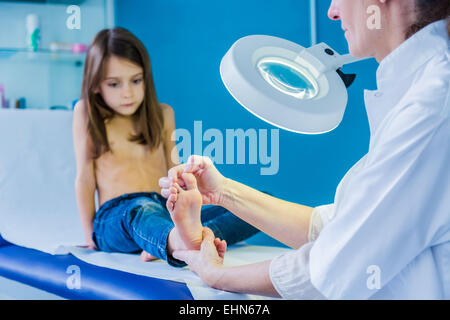 Doctor examining girl's foot. Banque D'Images