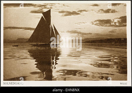 'Solnedgang' (coucher de soleil) par Anders Beer Wilse est une belle photographie de paysage d'un coucher de soleil sur un plan d'eau. Mettant en vedette des bateaux et des voiliers, l'image capture un moment serein dans la nature, emblématique du paysage côtier norvégien. Banque D'Images