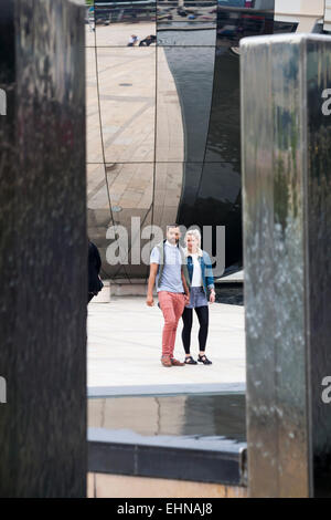 Couple walking Cours des pièces d'eau en face du planétarium en miroir au Millennium Square, Sphère, Harbourside Bristol en mai Banque D'Images