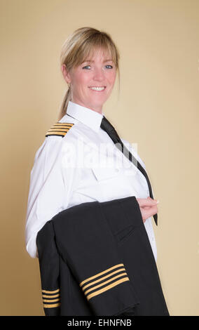 Belle femme debout en uniforme de capitaine de la compagnie aérienne holding jacket Banque D'Images