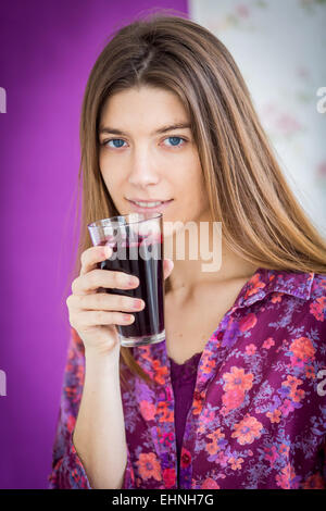 Femme à boire le jus de betteraves rouges. Banque D'Images