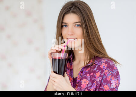 Femme à boire le jus de betteraves rouges. Banque D'Images