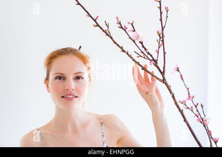 Femme en face d'un blooning Direction générale de Prunus . Banque D'Images