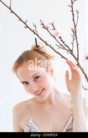 Femme en face d'un blooning Direction générale de Prunus . Banque D'Images