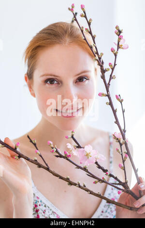 Femme en face d'un blooning Direction générale de Prunus . Banque D'Images