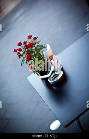 Bouquet de roses sur la table dans un café français Banque D'Images