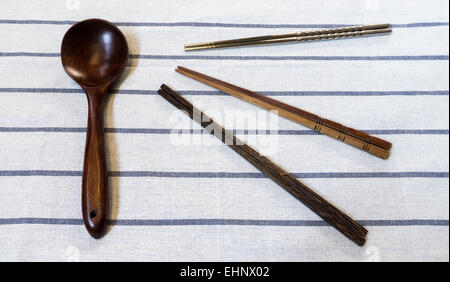 Trois types de baguettes et cuillère en bois grande table à rayures sur Salade Banque D'Images