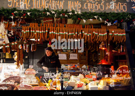 Une jeune fille vend la viande et fromage à un marché de Noël à Budapest, Hongrie Banque D'Images