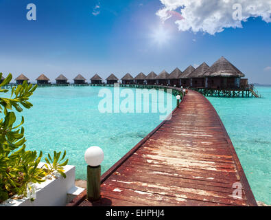 Maisons sur pilotis sur la mer. Les Maldives. Banque D'Images