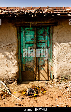 Une usure importante porte d'une maison indépendante à la campagne en dehors de Udaipur. Banque D'Images