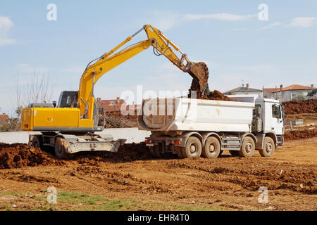 Chargement de camion benne excavatrice industrielle on construction site Banque D'Images