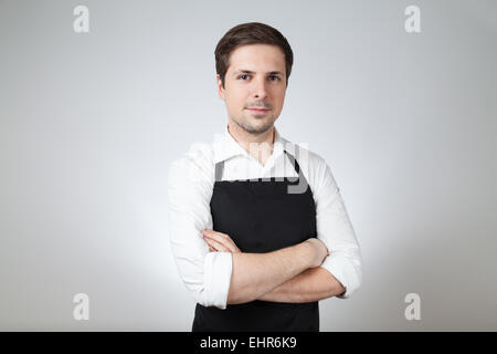 Shop assistant with apron sur fond gris (supermarché, café-bar) Banque D'Images