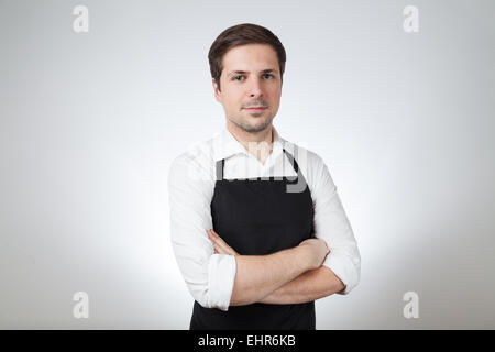 Shop assistant avec un tablier (fond gris) Banque D'Images