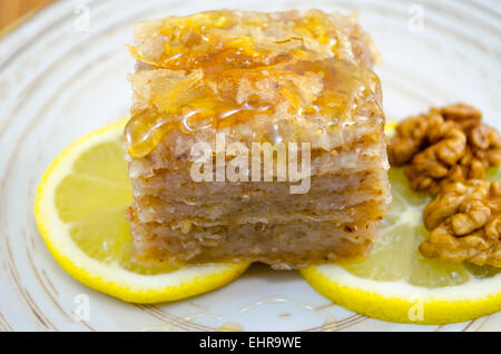 Baklava juteuse sur une assiette décorée avec du citron et noix, prêts à être mangés Banque D'Images