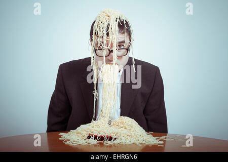 La suralimentation et le consumérisme concept. Nasty businessman eating pasta. Banque D'Images