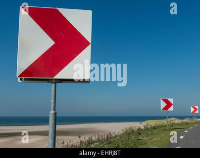 Signe rouge et blanc à l'avertissement de route pour un virage à droite à la côte. Banque D'Images