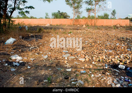 Un champ ouvert est parsemée d'ordures et les écorces de noix de coco à Skun, province de Kampong Cham, au Cambodge. Banque D'Images