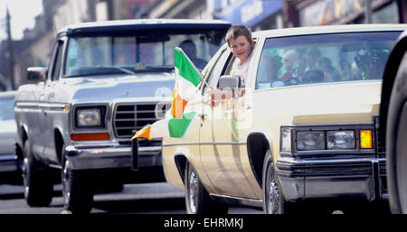 Tullamore, Irlande. 17 mars, 2015. Un garçon tenant un drapeau irlandais tout en roulant dans une voiture pendant les Ameriacan St Patricks Day Parade à Tullamore, Co Offaly, Irlande. Credit : James Flynn/Alamy Live News Banque D'Images