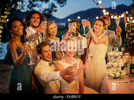 Les invités au mariage toasting with champagne pendant votre réception de mariage dans la région de jardin Banque D'Images