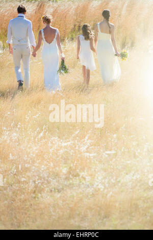 Jeune couple avec et de demoiselle girl walking in meadow Banque D'Images