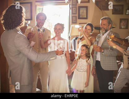 Jeune couple et invités toasting with champagne at wedding reception Banque D'Images