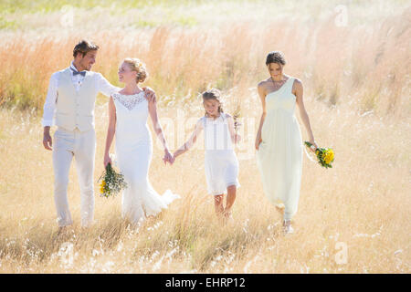 Jeune couple avec et de demoiselle girl walking in meadow Banque D'Images