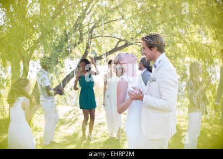 Young couple dancing at wedding reception dans le jardin intérieur Banque D'Images