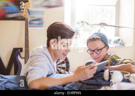 Deux adolescents sharing digital tablet in room Banque D'Images