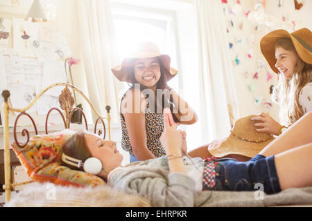 Trois jeunes filles s'amusant sur le lit dans la chambre Banque D'Images