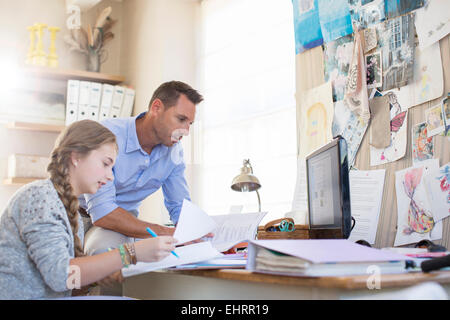 Aider Père fille adolescente avec ses devoirs Banque D'Images