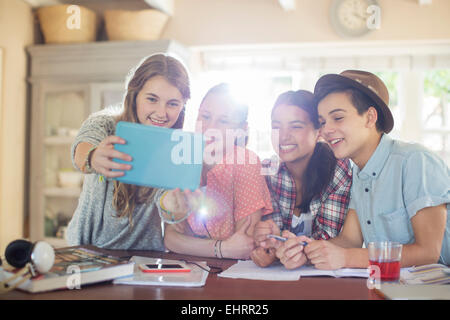 Groupe d'adolescents souriants prenant en selfies salle à manger Banque D'Images