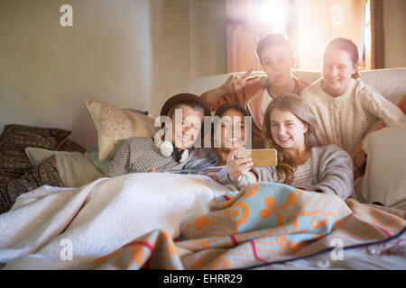 Groupe d'adolescents en tenant sur selfies sofa in living room Banque D'Images