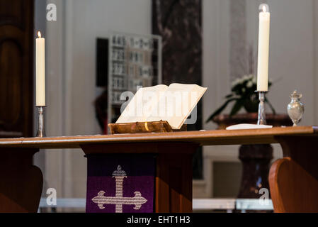 Bible ouverte et les bougies sur l'autel d'une église Banque D'Images