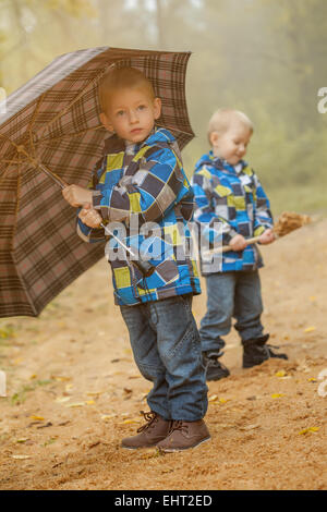 Les frères jumeaux mignons walking in autumn park Banque D'Images