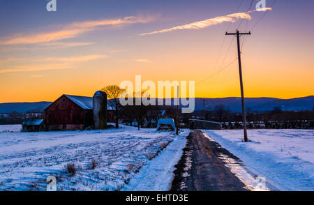 Grange et champs couverts de neige le long d'une route de campagne dans les régions rurales du comté de Frederick, Maryland. Banque D'Images