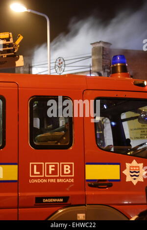 Ilford, Londres, Royaume-Uni. Mercredi 18 mars 2015. 11 sauvé du feu dans les appartements au-dessus d'une boutique à Ilford. Six pompiers de partout dans l'Est de Londres s'attaque à un incendie dans un immeuble d'appartements à Ilford, tôt ce matin. London Fire Brigade a signalé que six adultes et cinq enfants dont un bébé ont été secourus par les pompiers en utilisant des échelles. Il est signalé que l'incendie a éclaté dans un magasin ci-dessous les appartements. Banque D'Images