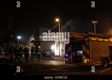 Ilford, Londres, Royaume-Uni. Mercredi 18 mars 2015. 11 sauvé du feu dans les appartements au-dessus d'une boutique à Ilford. Six pompiers de partout dans l'Est de Londres s'attaque à un incendie dans un immeuble d'appartements à Ilford, tôt ce matin. London Fire Brigade a signalé que six adultes et cinq enfants dont un bébé ont été secourus par les pompiers en utilisant des échelles. Il est signalé que l'incendie a éclaté dans un magasin ci-dessous les appartements. Banque D'Images