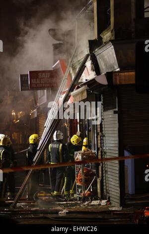 Ilford, Londres, Royaume-Uni. Mercredi 18 mars 2015. 11 sauvé du feu dans les appartements au-dessus d'une boutique à Ilford. Six pompiers de partout dans l'Est de Londres s'attaque à un incendie dans un immeuble d'appartements à Ilford, tôt ce matin. London Fire Brigade a signalé que six adultes et cinq enfants dont un bébé ont été secourus par les pompiers en utilisant des échelles. Il est signalé que l'incendie a éclaté dans un magasin ci-dessous les appartements. Banque D'Images