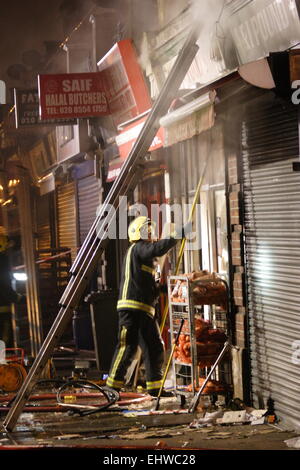 Ilford, Londres, Royaume-Uni. Mercredi 18 mars 2015. 11 sauvé du feu dans les appartements au-dessus d'une boutique à Ilford. Six pompiers de partout dans l'Est de Londres s'attaque à un incendie dans un immeuble d'appartements à Ilford, tôt ce matin. London Fire Brigade a signalé que six adultes et cinq enfants dont un bébé ont été secourus par les pompiers en utilisant des échelles. Il est signalé que l'incendie a éclaté dans un magasin ci-dessous les appartements. Banque D'Images