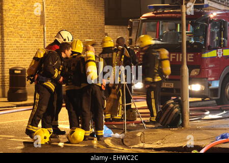 Ilford, Londres, Royaume-Uni. Mercredi 18 mars 2015. 11 sauvé du feu dans les appartements au-dessus d'une boutique à Ilford. Six pompiers de partout dans l'Est de Londres s'attaque à un incendie dans un immeuble d'appartements à Ilford, tôt ce matin. London Fire Brigade a signalé que six adultes et cinq enfants dont un bébé ont été secourus par les pompiers en utilisant des échelles. Il est signalé que l'incendie a éclaté dans un magasin ci-dessous les appartements. Banque D'Images