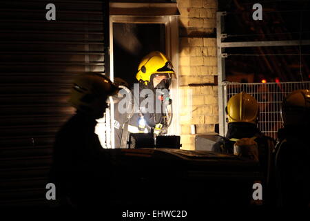 Ilford, Londres, Royaume-Uni. Mercredi 18 mars 2015. 11 sauvé du feu dans les appartements au-dessus d'une boutique à Ilford. Six pompiers de partout dans l'Est de Londres s'attaque à un incendie dans un immeuble d'appartements à Ilford, tôt ce matin. London Fire Brigade a signalé que six adultes et cinq enfants dont un bébé ont été secourus par les pompiers en utilisant des échelles. Il est signalé que l'incendie a éclaté dans un magasin ci-dessous les appartements. Banque D'Images