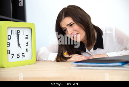 Two businesswomen assis à la table et à la recherche sur l'horloge Banque D'Images