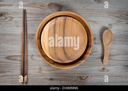 Vue aérienne d'assiettes vides et sushi baguettes sur la vieille table en bois. Lumière dramatique. Banque D'Images