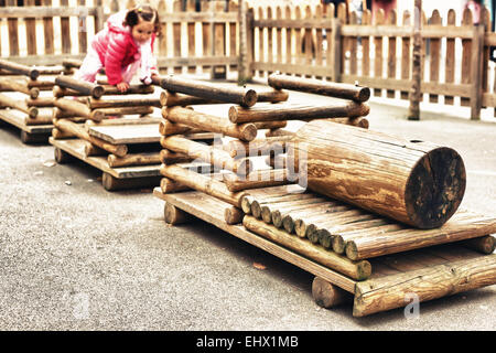 Toddler playing sur un train en bois, une aire de jeux pour enfants dans un parc public Banque D'Images