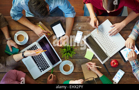 Portrait de personnes à table de réunion et de travail avec les ordinateurs portables et claviers Banque D'Images