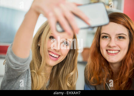 Happy girl friends en tenant un smartphone avec selfies, Munich, Bavière, Allemagne Banque D'Images